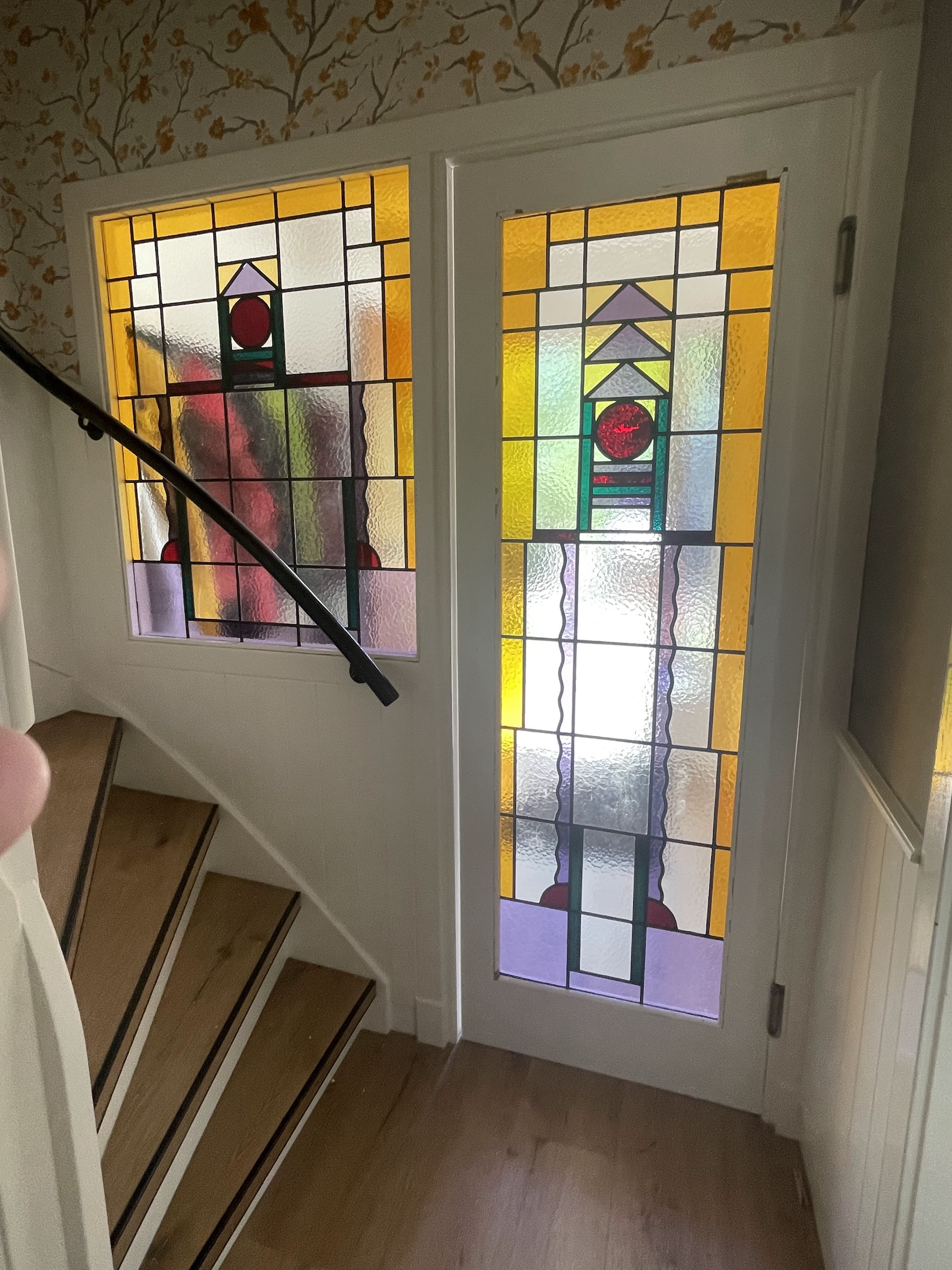 Trappenhuis met twee gekleurde glas-in-loodpanelen in geel, rood en paars