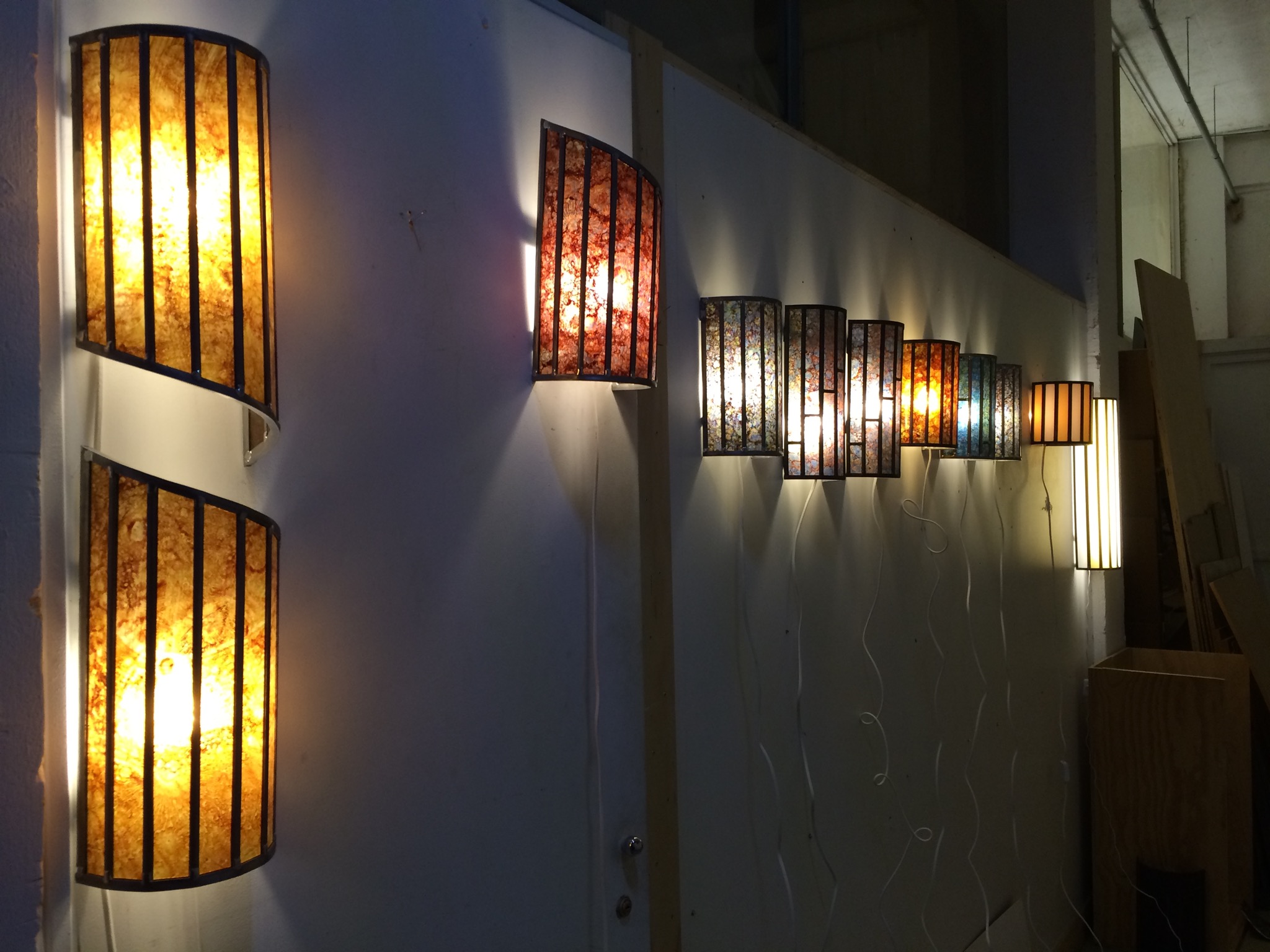 Rij amberkleurige glas-in-lood panelen aan een wand